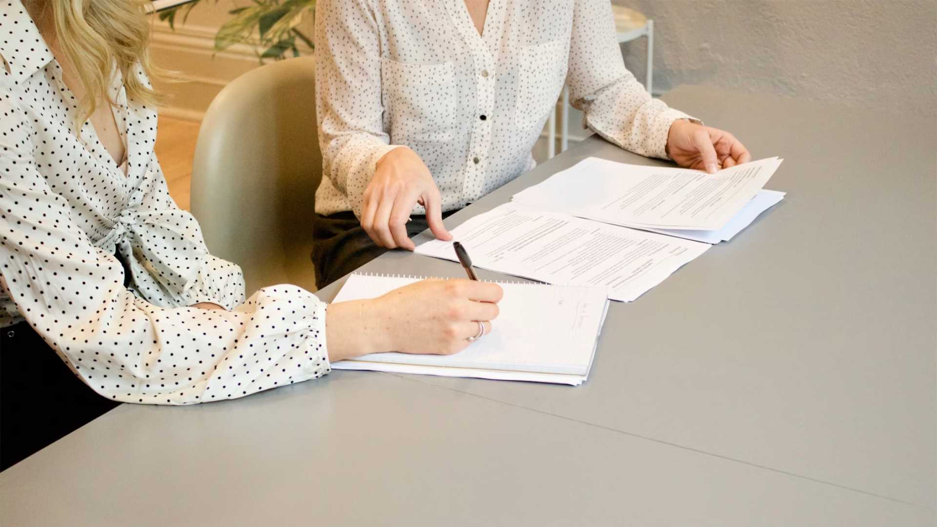 Real-Estate-Reporting-Law-FinCEN Two Professionals Pointing at a Report on a Desk