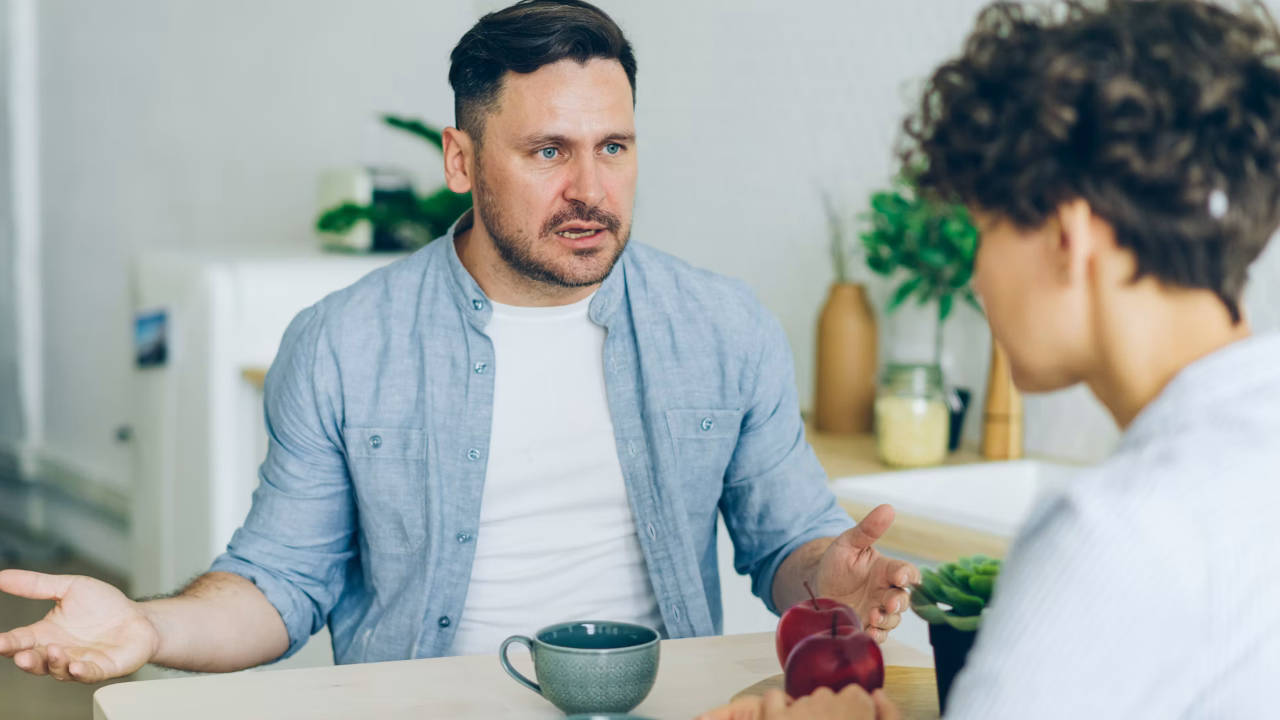 A couple arguing at a table.